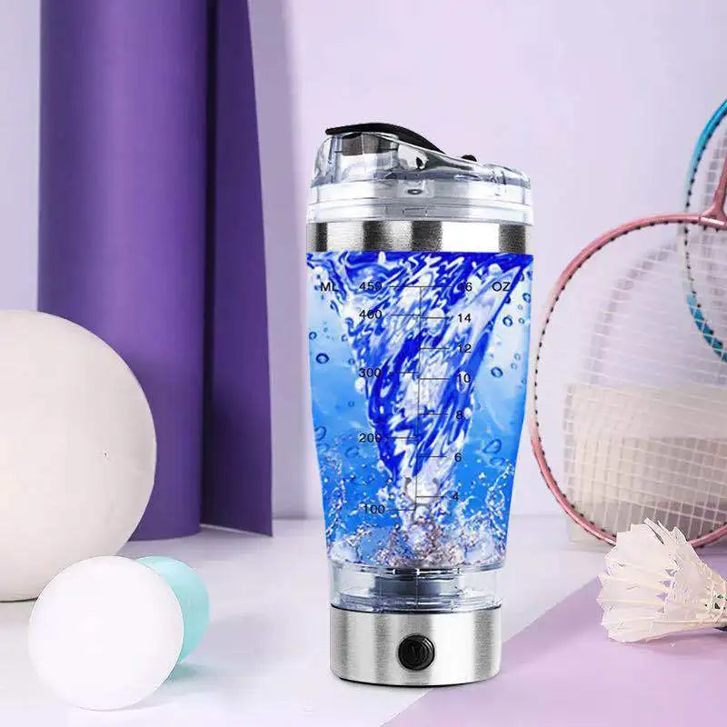 Electric protein shaker bottle mixing blue drink on table