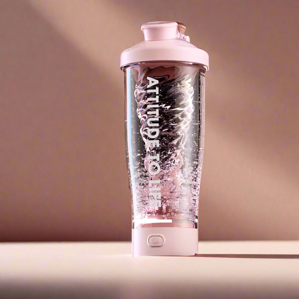 A pink 650 ml electric protein shaker blends powder and water in a studio setup.
