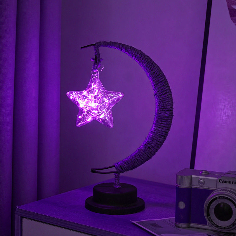 Moon-shaped glass night light with hanging star glowing in purple LED light