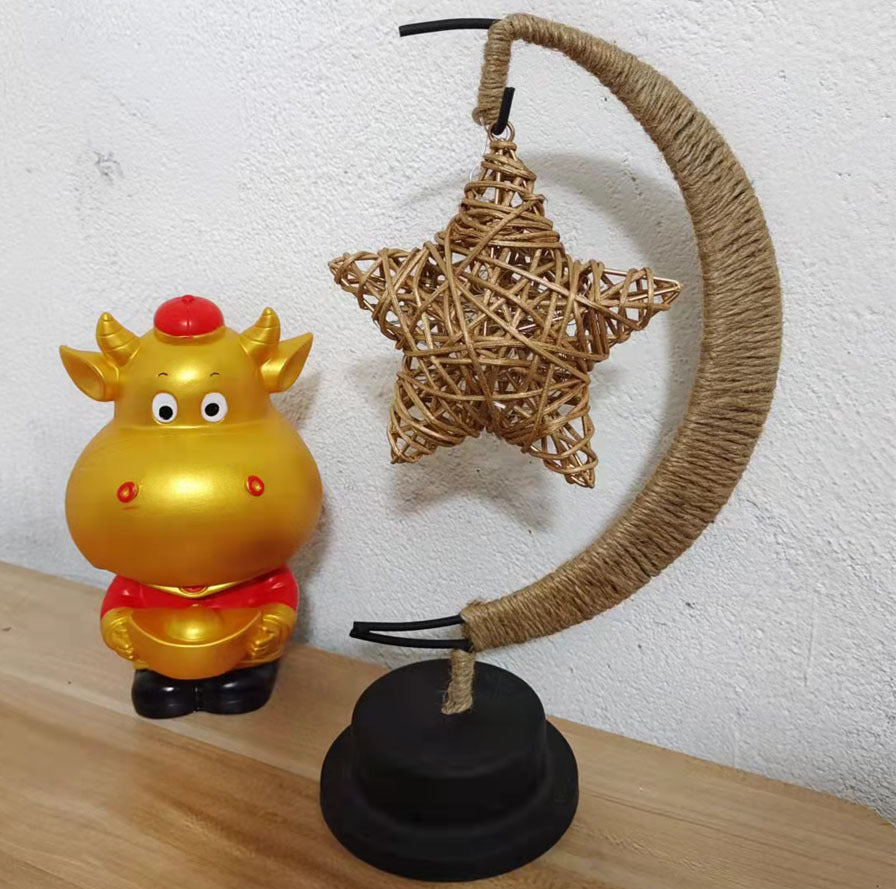 Moon-shaped glass night light with hanging star mounted near wall for indoor decor