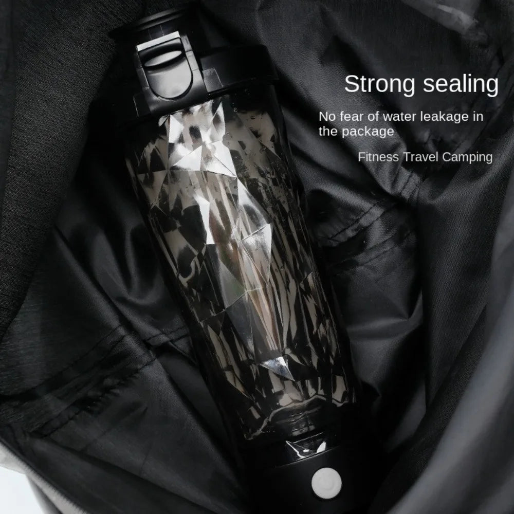 Black portable protein shaker bottle resting on gym bag