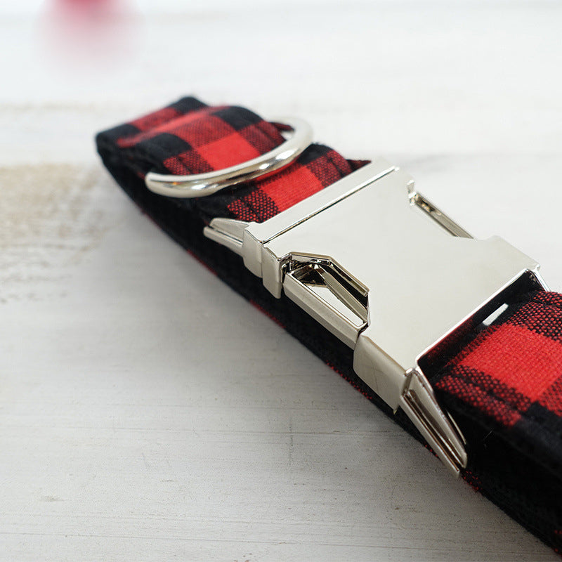Close-up view of red and black grid dog collar with secure metal buckle