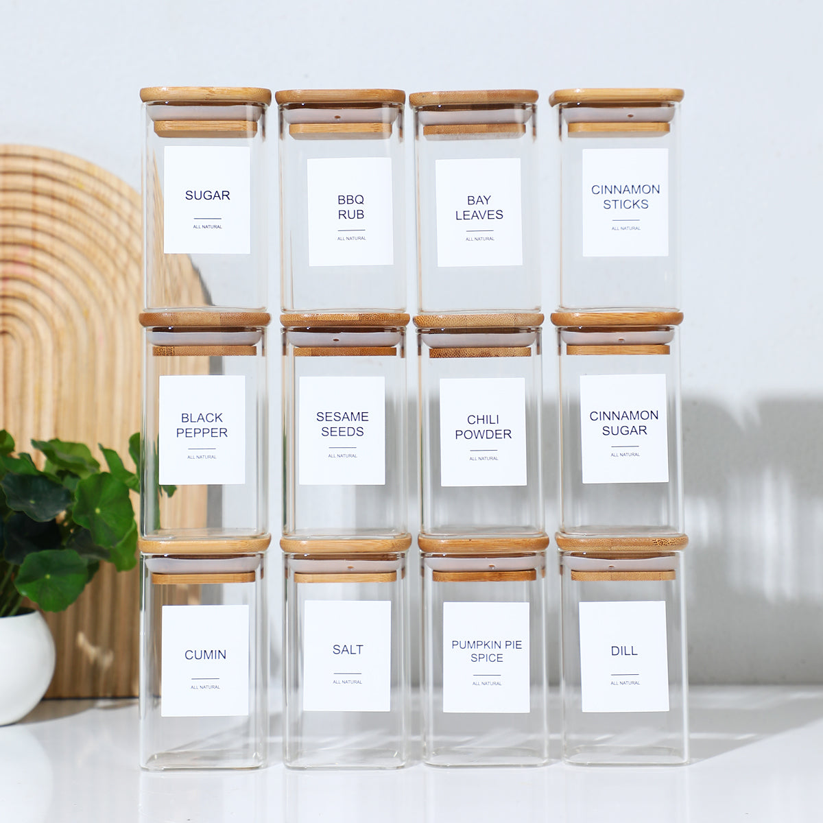 Rows of labeled square glass jars with bamboo lids