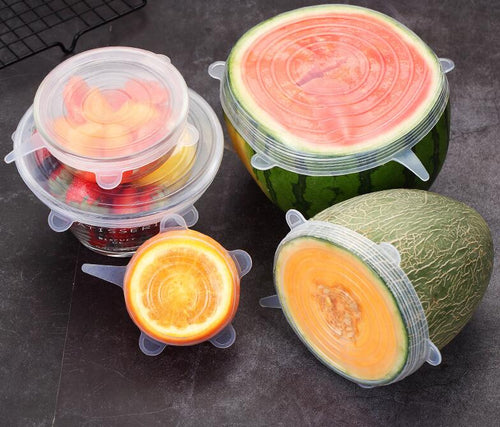 Silicone stretch lid sealed over a halved melon in a bowl of mixed cut fruit