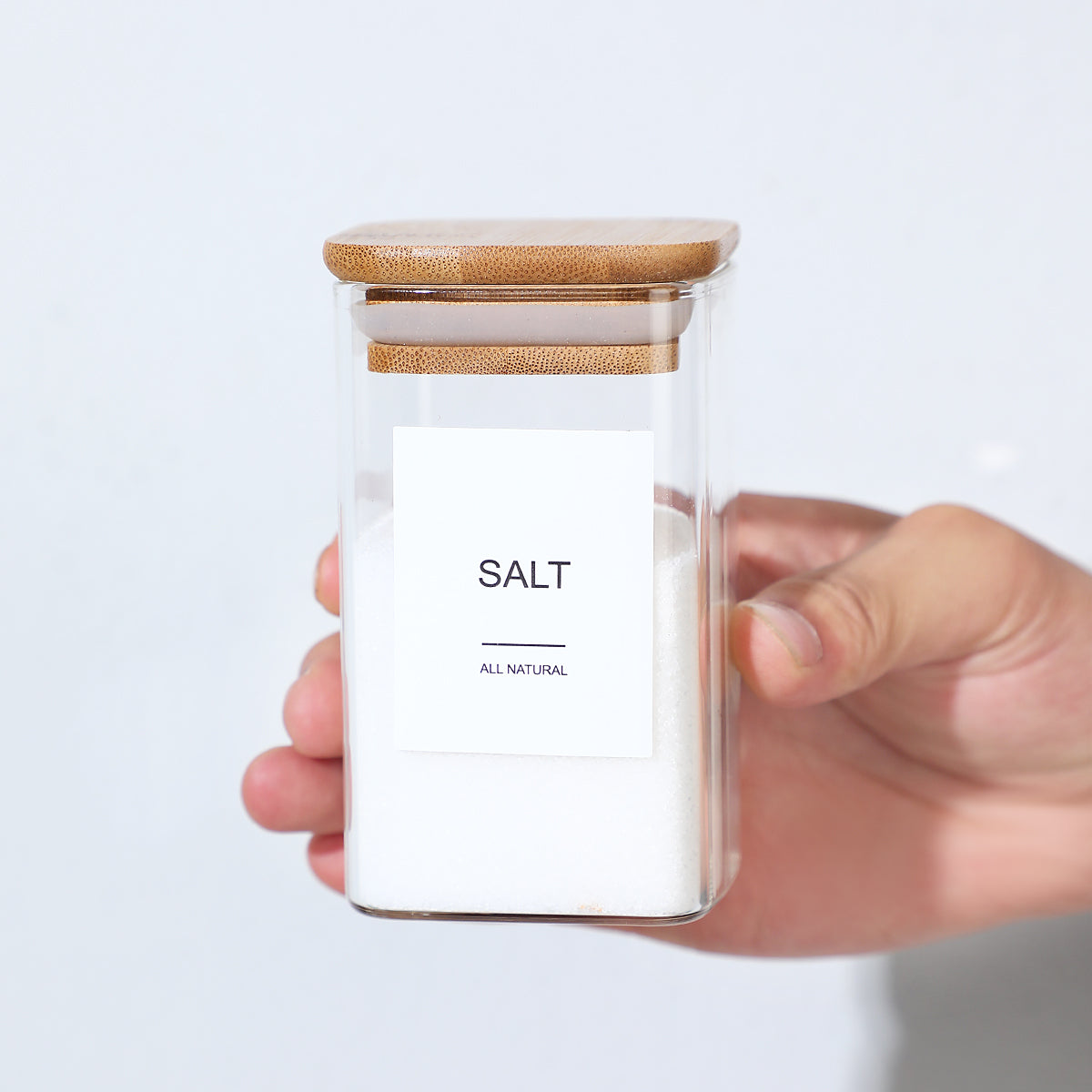 Hand holding a glass jar labeled salt