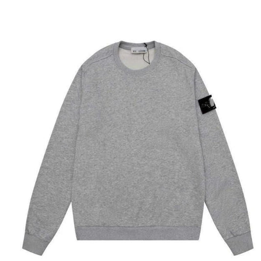 A Heather gray crewneck sweatshirt with ribbed cuffs and hem, featuring a small black patch on the sleeve.