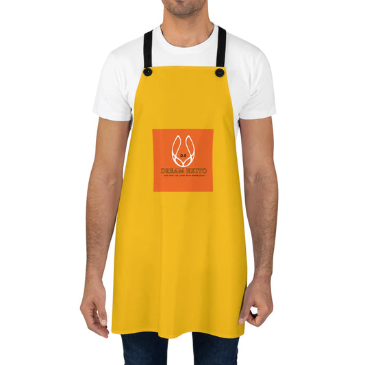 A bright yellow apron with black straps worn over a white t-shirt, featuring the Dream Exito logo in an orange box.