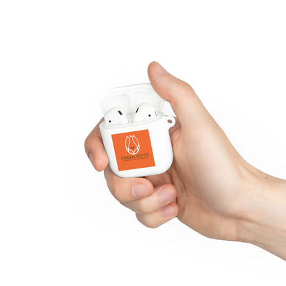 A hand holding a white earbud case with an orange sticker.