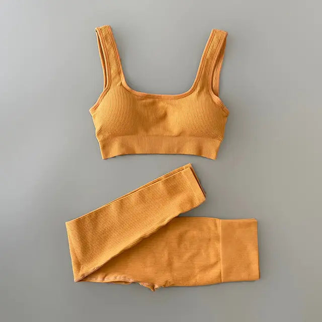 A light yellow-colored ribbed workout set with sports bra top and high-waisted shorts against gray background