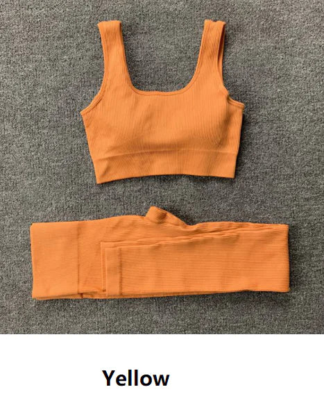 A yellow-colored ribbed workout set with sports bra top and high-waisted shorts against gray background
