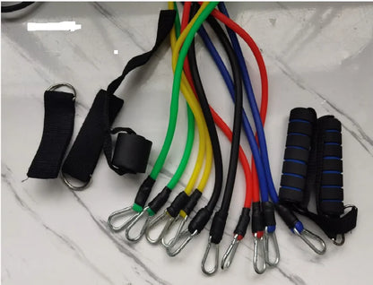 Colorful resistance bands with black handles and carabiners laid out on a marble-like surface with accessories.