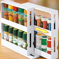 White two-tier rotating spice organizer pulled out from a kitchen cabinet