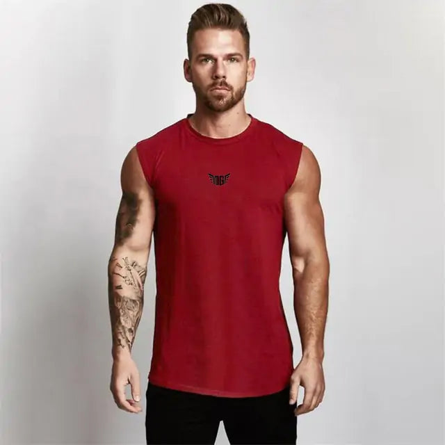 Fit model in red sleeveless athletic shirt with black wing logo, detailed arm tattoo, against white setting