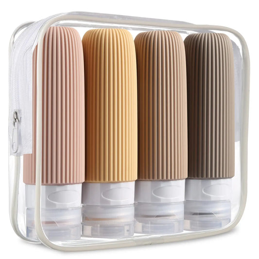 Four ribbed silicone travel bottles in neutral colors are arranged in a clear toiletry case.