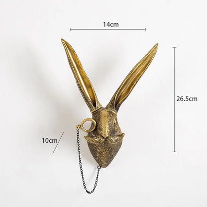 Gold-colored hare head wall hook with monocle and chain, annotated with measurements