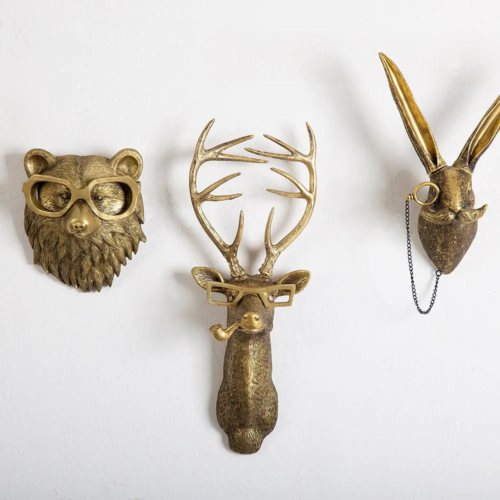 Golden animal wall mounts featuring a bear, deer, and fox, each wearing glasses