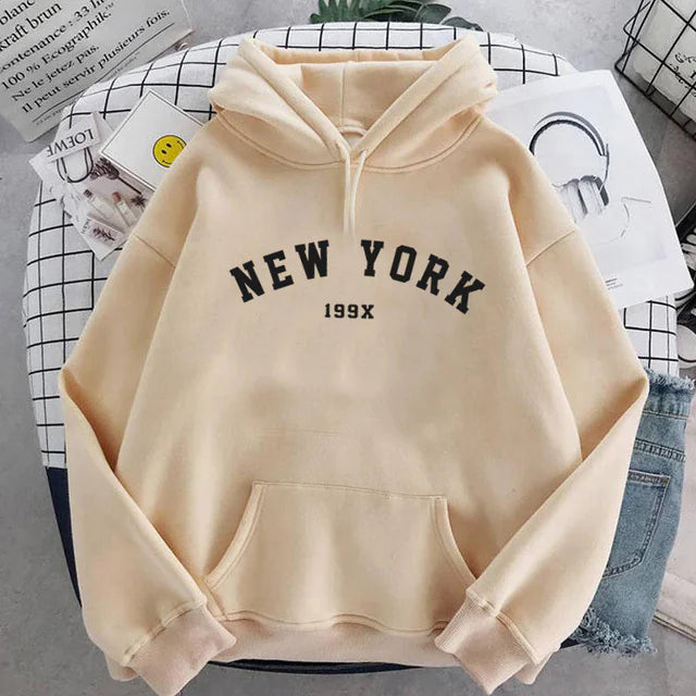 Khaki New York pullover hoodie with black lettering and 199X detail, shown on gridded surface design