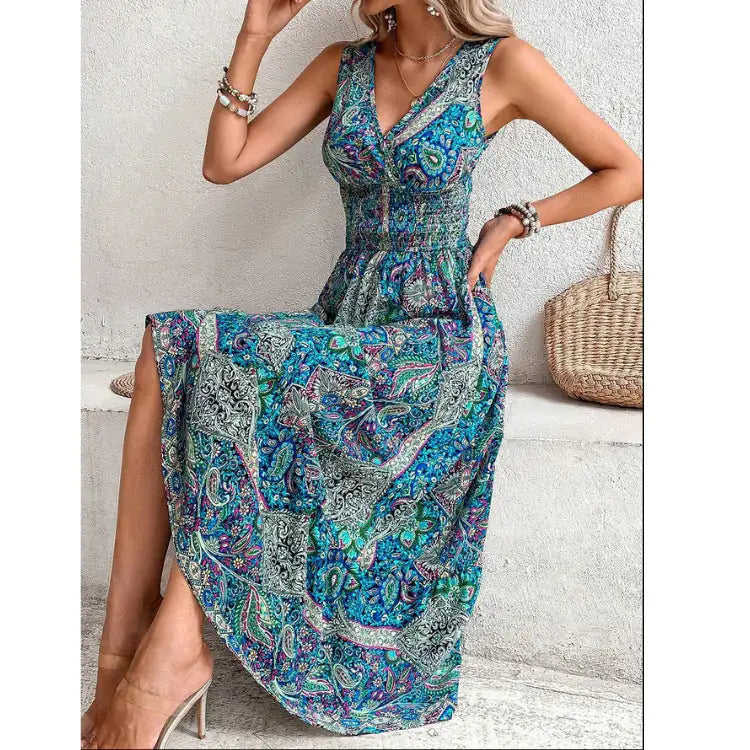 Model in blue paisley midi dress with V-neck, elastic waist, and bracelets, posing by wall