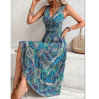 Model in blue paisley midi dress with V-neck, elastic waist, and bracelets, posing by wall