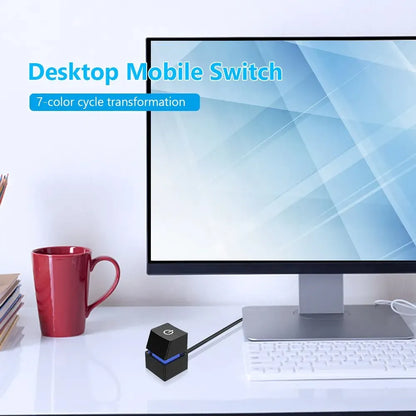 Modern desk setup with a computer monitor, red mug, and black power device.