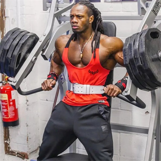 Muscular athlete in red tank top and weight belt performs exercise at gym, dreadlocks and focused expression