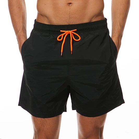 Navy blue swim shorts with orange drawstring, shown on athletic torso model against white background