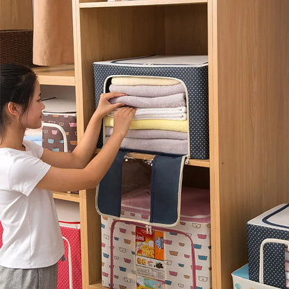 Person organizing folded towels in navy polka dot storage box placed on wooden shelf unit