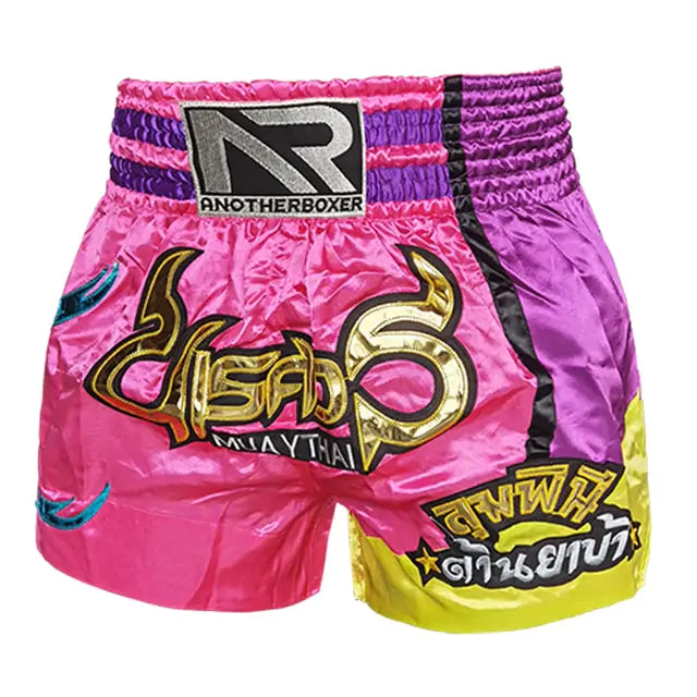 Pink and purple color-block Muay Thai shorts with Thai script and yellow accent panel
