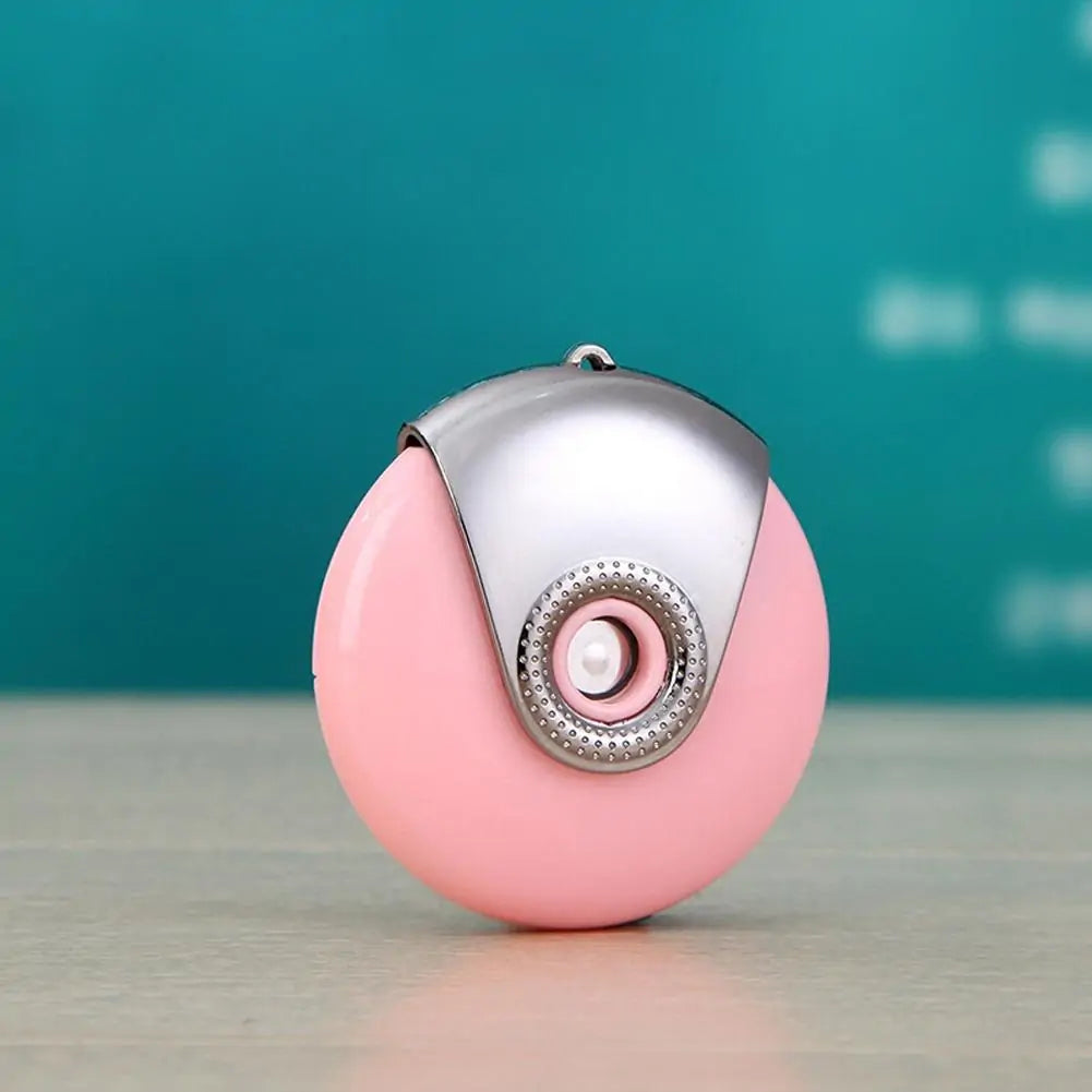 Pink portable facial mister with silver fan-shaped cap on teal background.