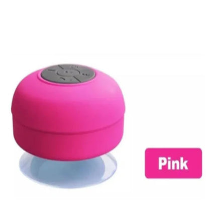 Pink wireless speaker with top control panel and suction cup base.