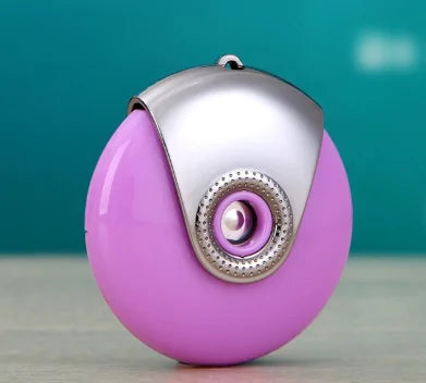 Purple egg-shaped facial mister with silver metal cap and circular nozzle on teal background.