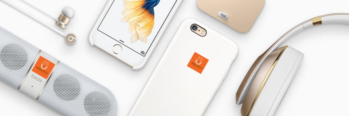 Smartphone with a white case featuring an orange square logo, surrounded by electronic devices on a white background.