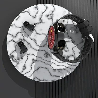 Smartwatch with a red face and black strap on a marble surface, accompanied by two black earbuds.