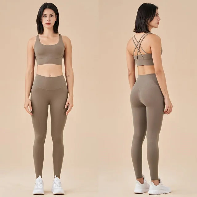 Taupe athletic set featuring crop top with criss-cross back straps and high-waisted leggings