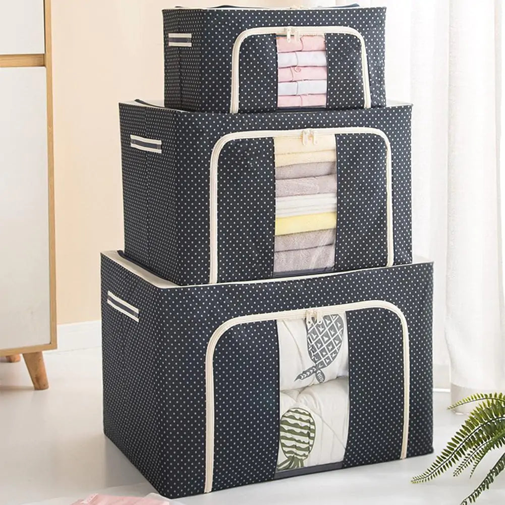 Three stacked storage boxes in navy polka-dot fabric with clear windows showing folded linens, white trim detail