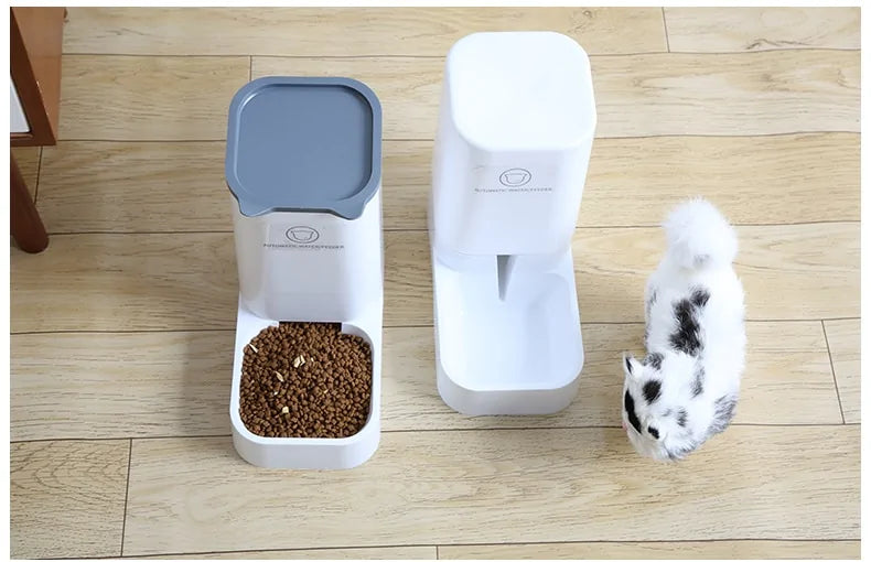 Top-down view of automatic pet feeders on wooden floor with cat investigating the water dispenser unit