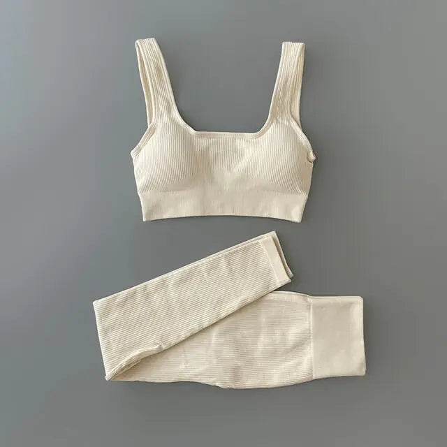 White -colored ribbed workout set with sports bra top and high-waisted shorts against gray background