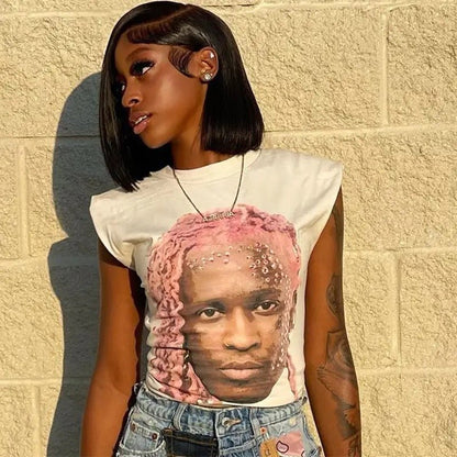 Woman with short black hair and a white graphic tee featuring a portrait of a person with pink hair.