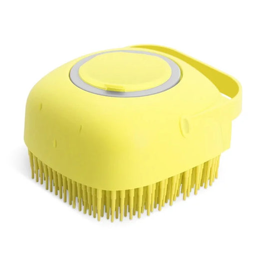 Yellow silicone pet brush with soft bristles and circular shampoo dispenser cap, viewed from above