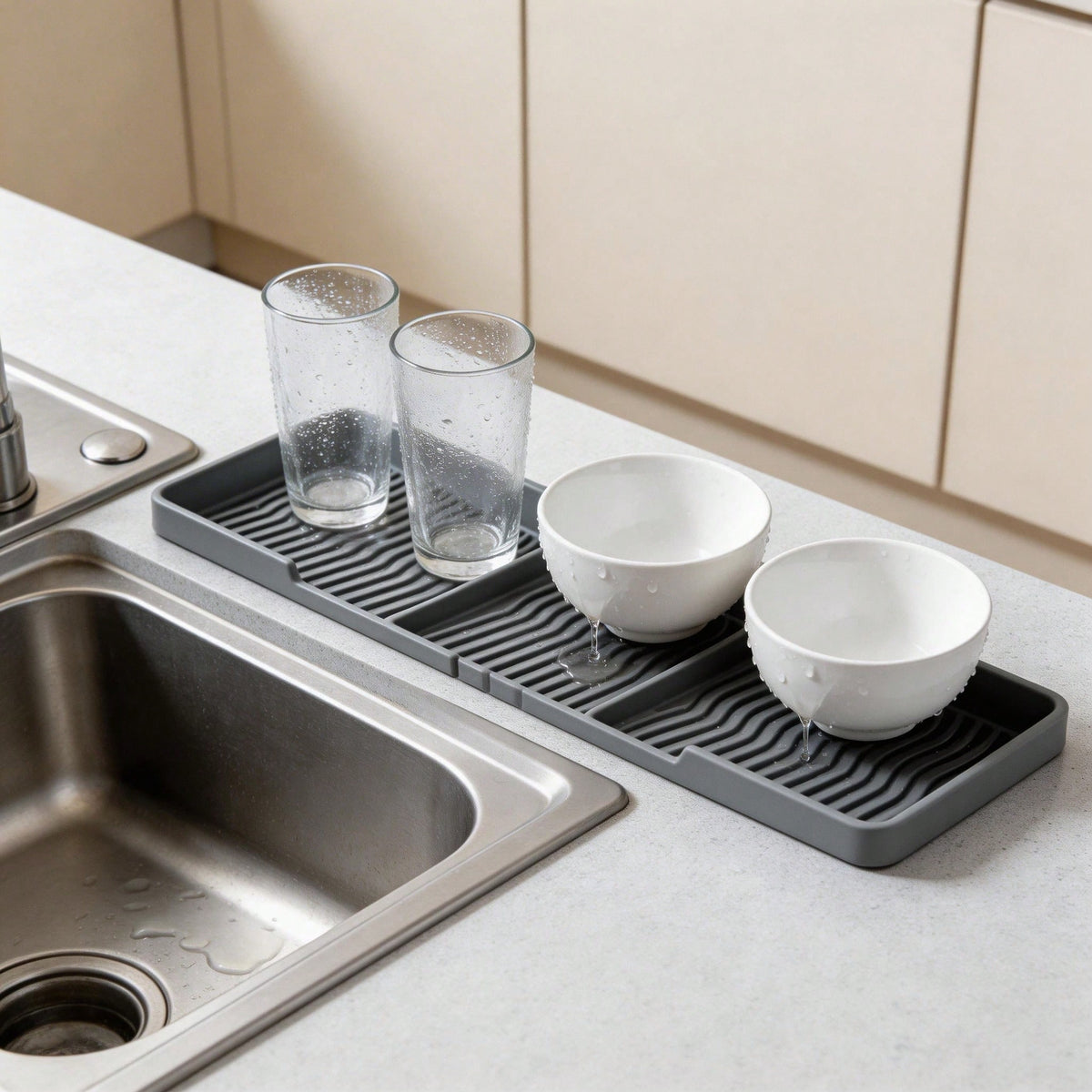 Grey silicone tray on a sink counter holding two glasses and two bowls