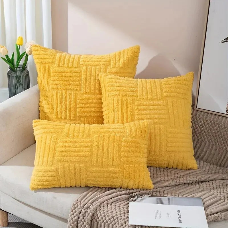 Yellow boho faux fur throw pillow covers stacked on sofa