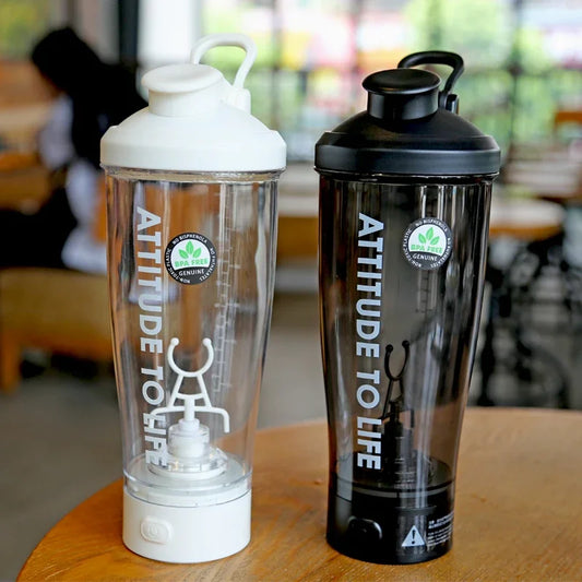 Electric protein shaker bottles in black and white on a table for mixing shakes and supplements.