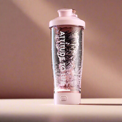 A pink 650 ml electric protein shaker blends powder and water in a studio setup.