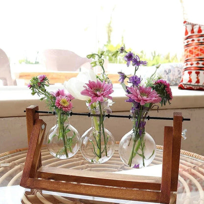 Triple glass tube hydroponic vase in wooden frame filled with flowers