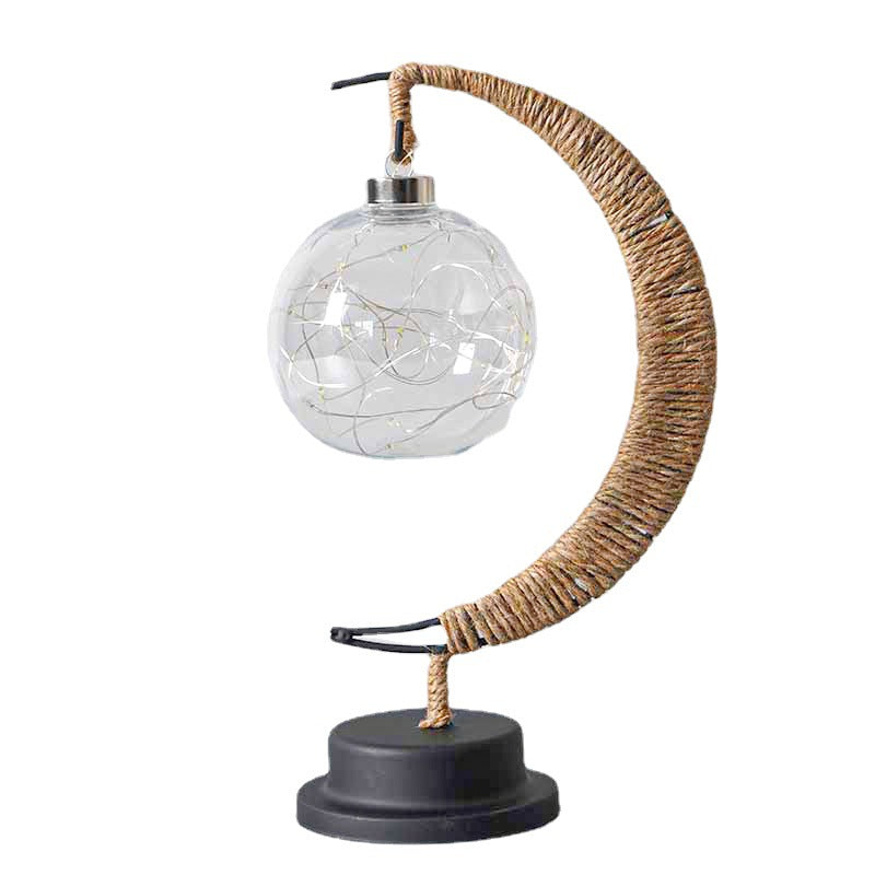 Moon-shaped glass night light with clear globe illuminated in warm light