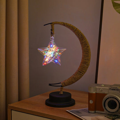 Close-up of moon-shaped glass night light with globe glowing in multicolor lights
