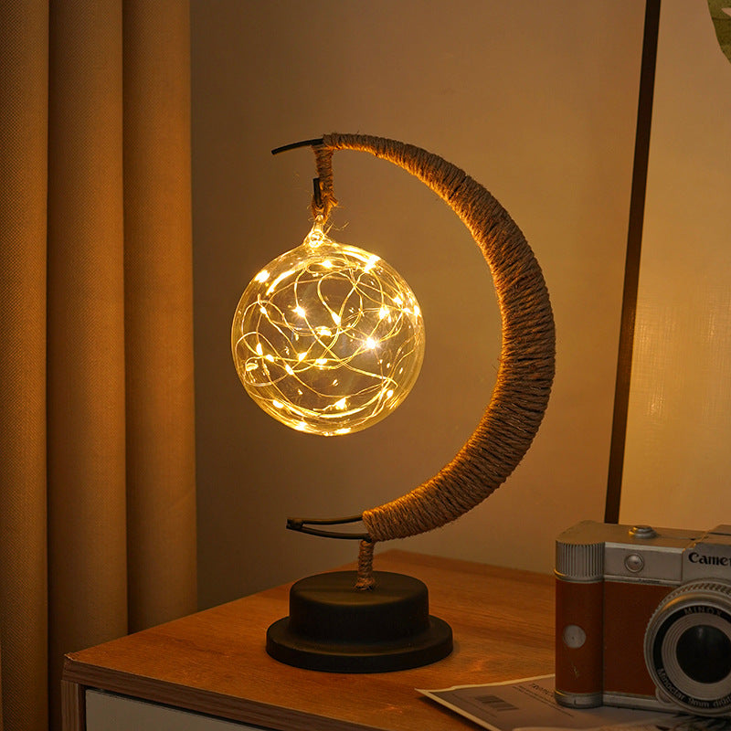 Moon-shaped glass night light with round globe emitting warm indoor glow