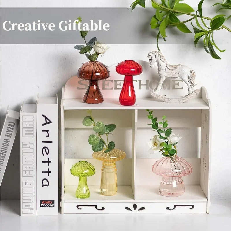 Assorted mushroom glass vases in different colors styled on shelf with books and plants