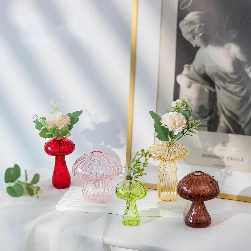 Colored mushroom shaped vases including red, pink, green and brown displayed on a table