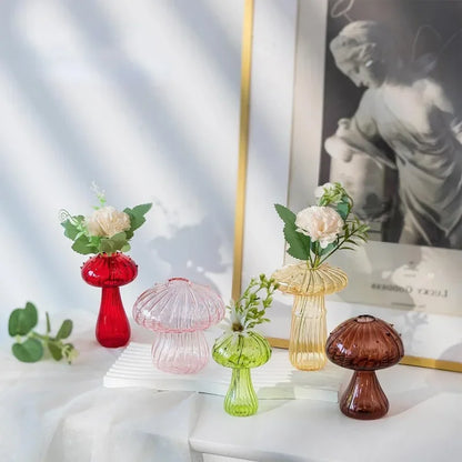 Colored mushroom shaped vases including red, pink, green and brown displayed on a table